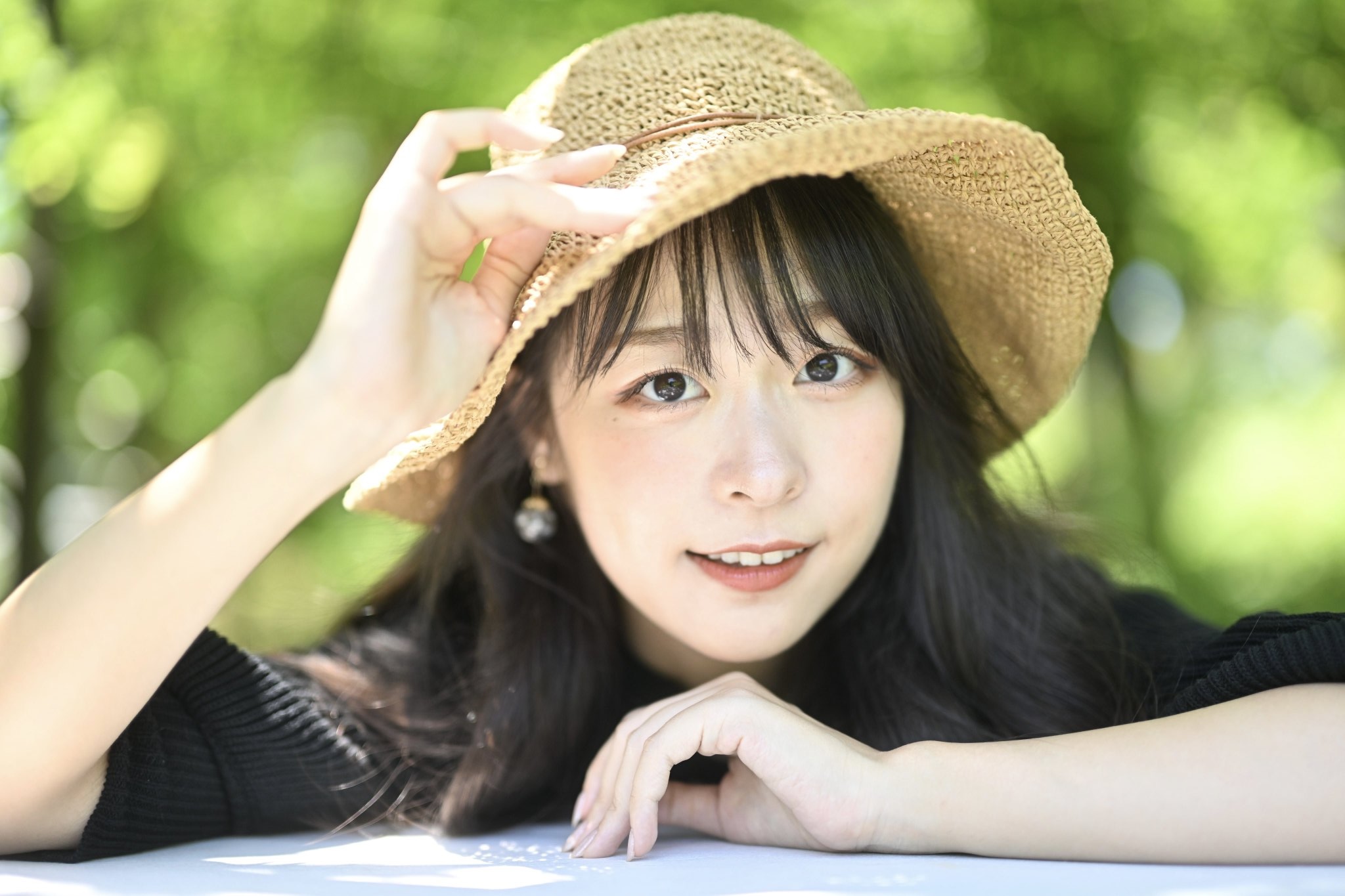 麦わら帽子をかぶった新緑を背景にしたAR!NAポートレート写真